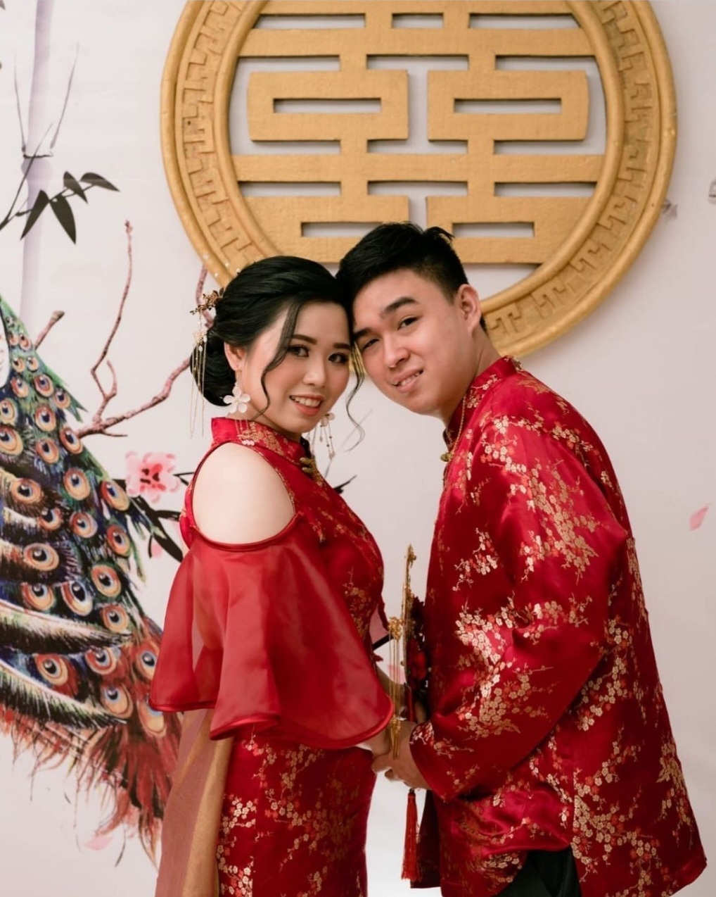 Tuan Kenny dan istri memakai dress cheongsam couple dengan tambahan detachable train di bagian pinggang dari Uptown Gown