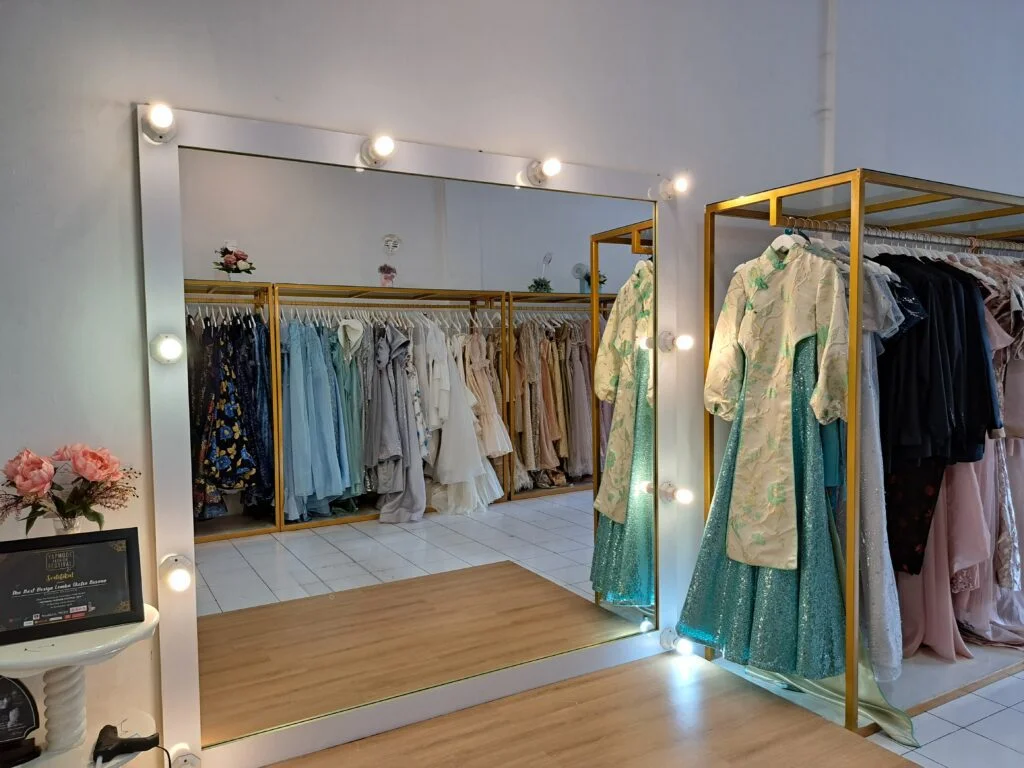 Potret kaca utama di ruang fitting Uptown Gown beserta beberapa gaun buatan Uptown Gown - Sewa Gaun Medan